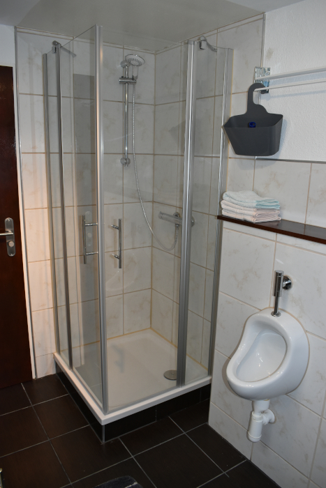 Dusche mit Urinal im Bad der Ferienwohnung am Steigerwaldrand